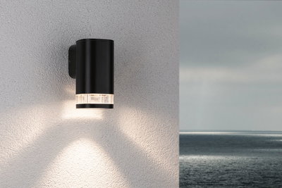 Schwarze Außenwandleuchte aus Metall mit klarem Glas und warmweißem Licht für moderne Fassadenbeleuchtung