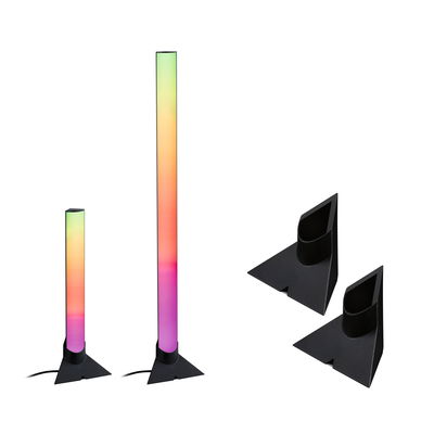 Twee meerkleurige LED-vloerlampen met zwarte voet en twee zwarte houders voor sfeerverlichting.