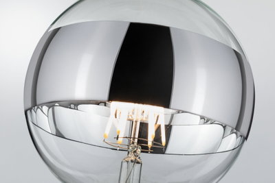 Nahaufnahme einer klaren Glühbirne mit sichtbarem LED-Filament und silberner Beschichtung für moderne Beleuchtung