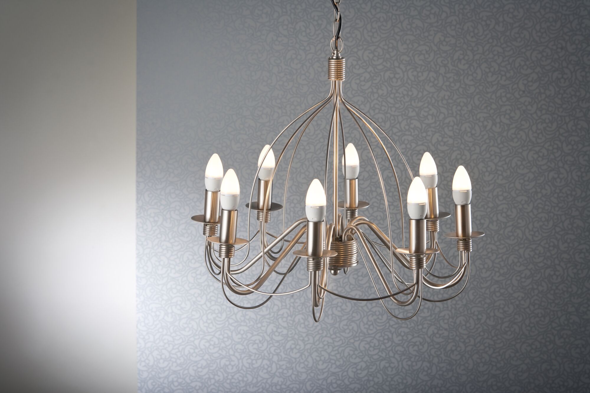 Modern brushed metal chandelier with ten warm white LED candle bulbs for stylish home lighting.