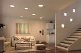 Modernes Wohnzimmer mit weißen LED-Deckenleuchten und quadratischen Wandlampen an der Treppe