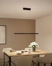 Suspension LED noire en métal au-dessus d'une table en bois avec tulipes blanches et service à café dans la salle à manger