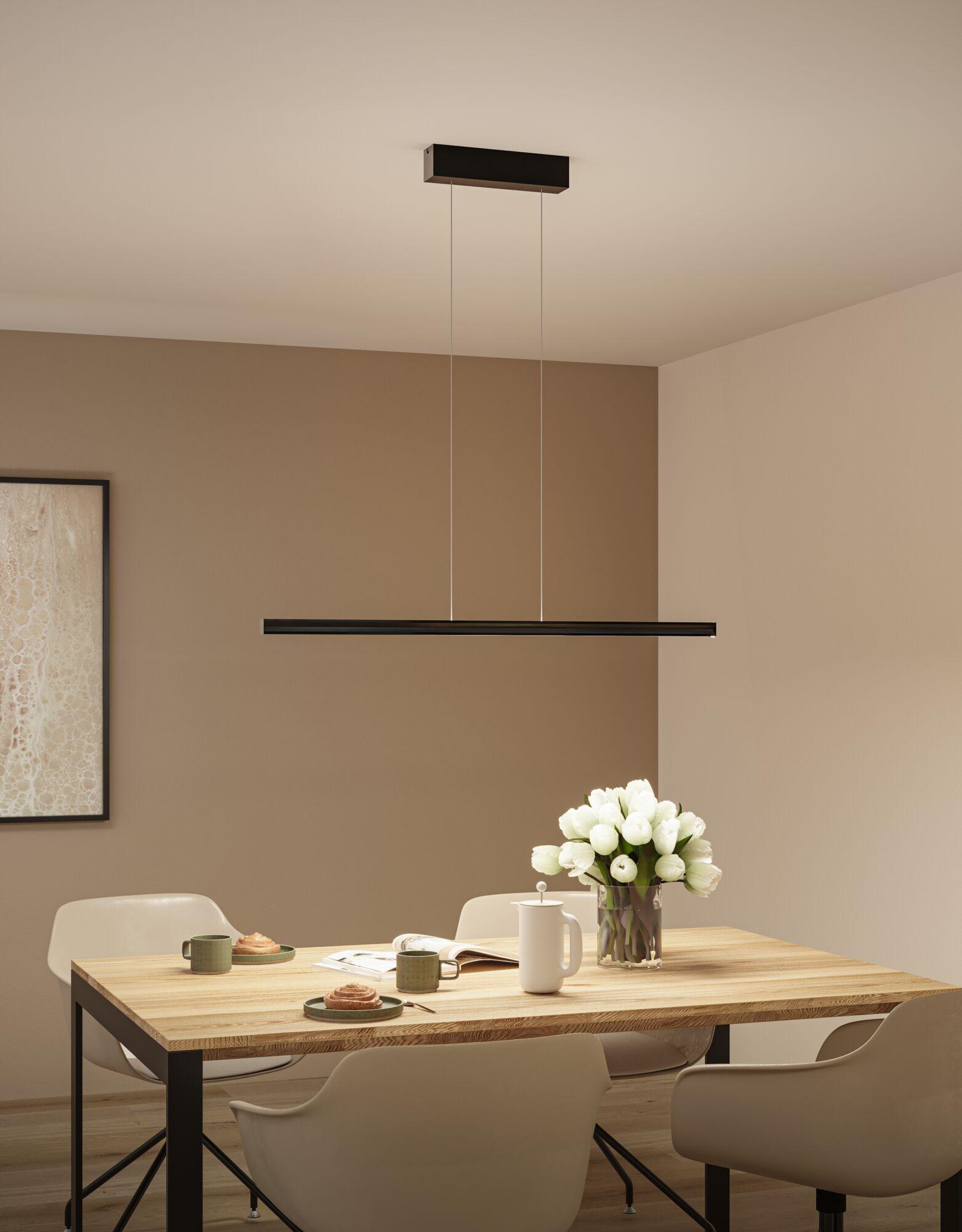 Suspension LED noire en métal au-dessus d'une table en bois avec tulipes blanches et service à café dans la salle à manger