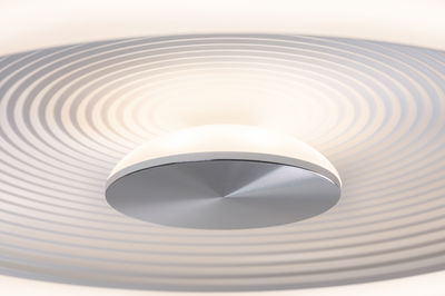 Plafonnier moderne avec abat-jour en plastique blanc et centre en métal argenté pour salon.
