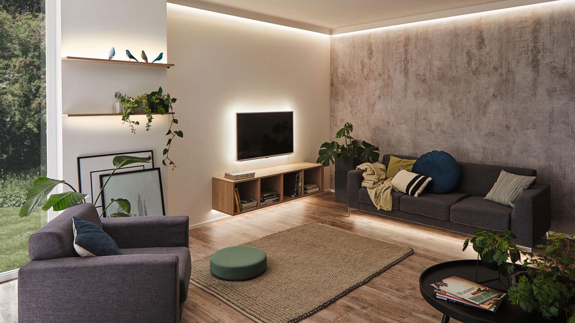 Modernes Wohnzimmer mit grauem Sofa, Holzregal und indirekter LED-Beleuchtung für gemütliche Atmosphäre