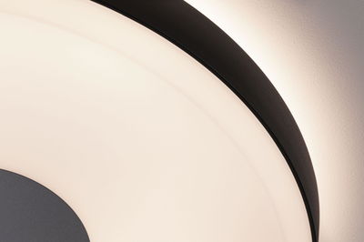 Gros plan d'un plafonnier rond avec cadre noir et lumière blanche chaude pour espaces de vie