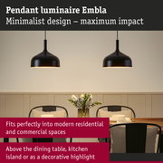 Black metal Embla pendant luminaire with minimalist design hanging above dining table in modern room