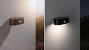 Schwarze LED-Außenwandleuchte mit Bewegungsmelder an weißer Wand, Tag- und Nachtansicht