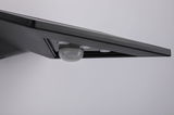 Black LED wall light with integrated motion sensor made of plastic for indoor use
