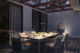 Modern outdoor dining area with white table, grey chairs, and black pendant light for garden lighting