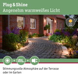 Außenbeleuchtung mit warmweißem Licht entlang eines gepflasterten Gartenwegs mit Pflanzen und Hausfassade