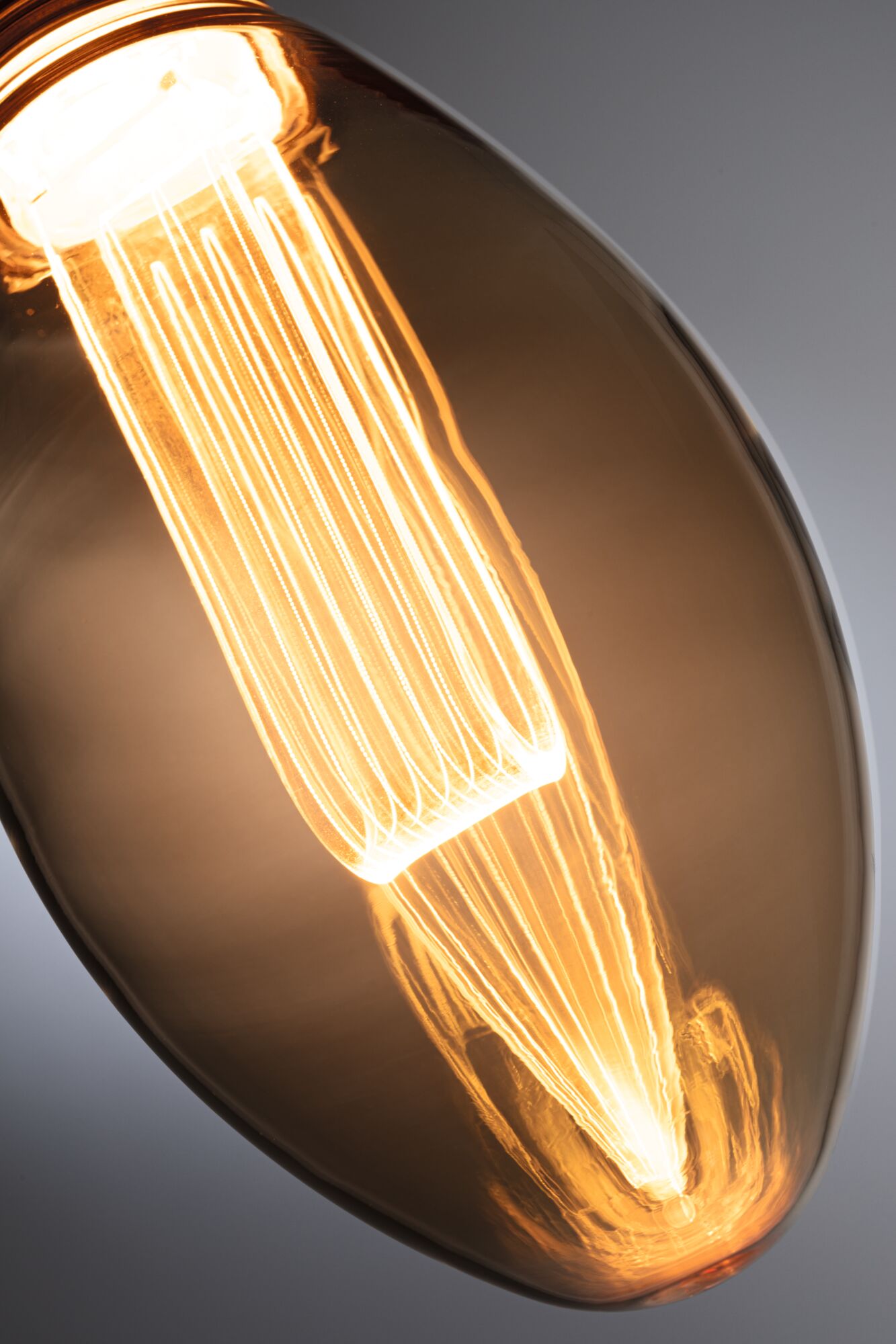 Close-up of a warm glowing light bulb with brown glass for decorative lighting use.