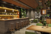 Modernes Barinterieur mit Holztheke, grünen Sitzmöbeln und weißen Pendelleuchten für stimmungsvolle Beleuchtung