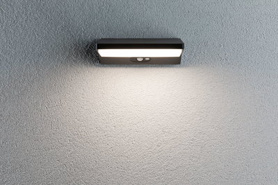 Applique murale LED noire avec détecteur de mouvement sur mur gris pour éclairage extérieur et sécurité