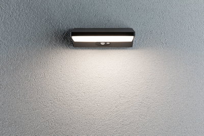 Schwarze LED-Wandleuchte mit Bewegungsmelder an grauer Wand für Außenbeleuchtung und Sicherheit