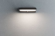 Black metal LED wall light with motion sensor on grey wall for outdoor lighting