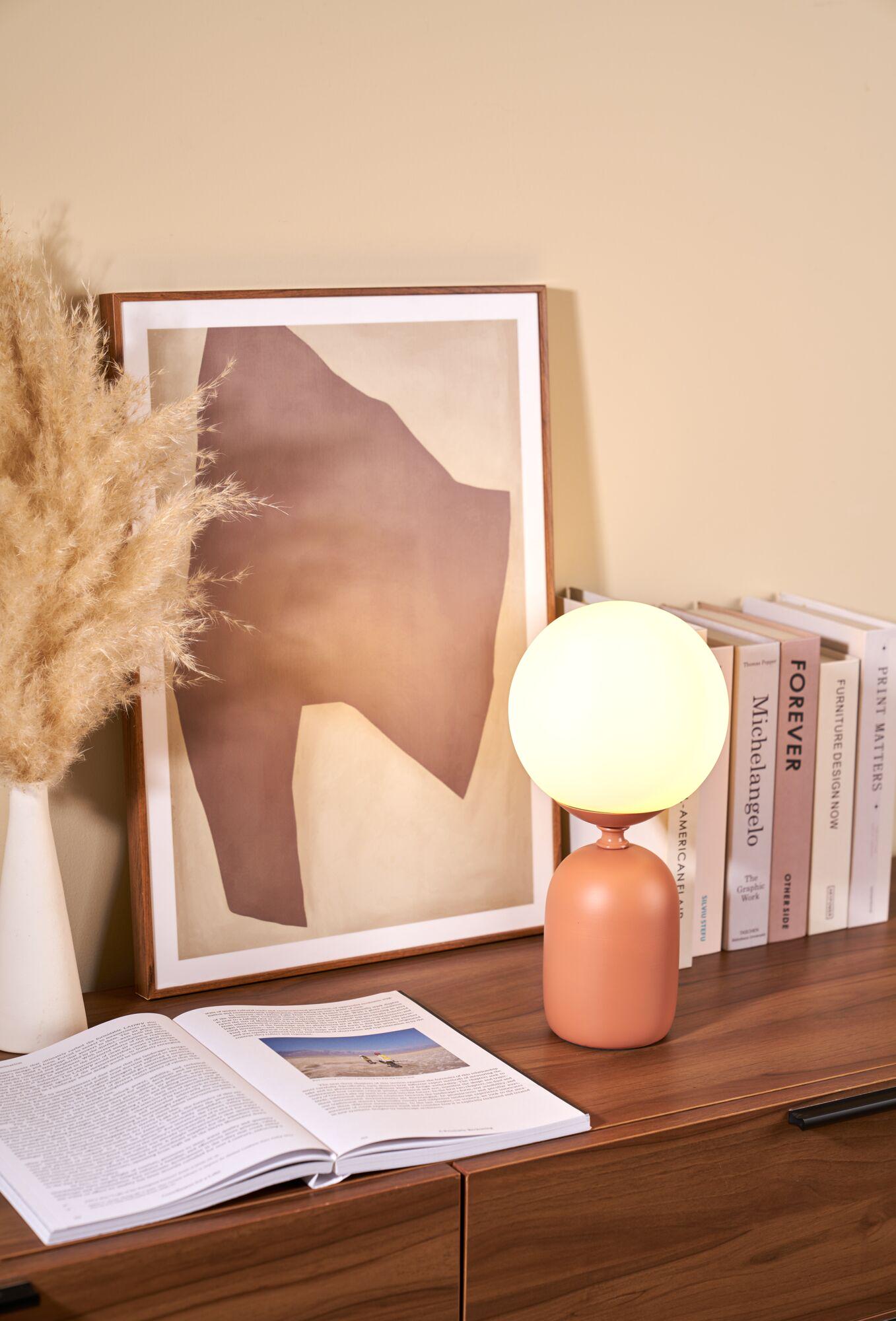 Moderne Tischlampe mit rundem, weißem Glas und mattem, terrakottafarbenem Keramikfuß auf Holzkommode
