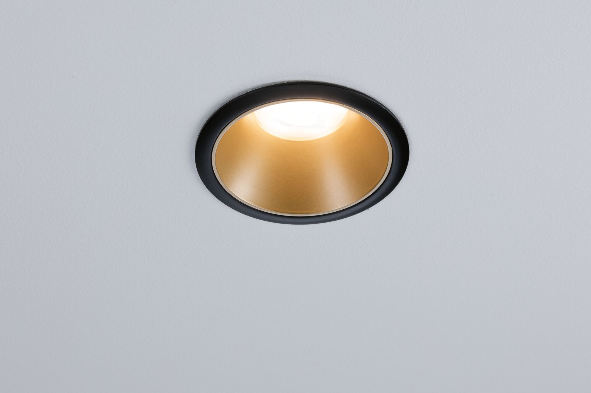 Spot encastré noir avec réflecteur doré dans un plafond blanc pour éclairage LED moderne