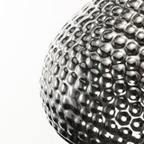 Close-up of a spherical lamp made of shiny, textured silver metal with LED lighting effect