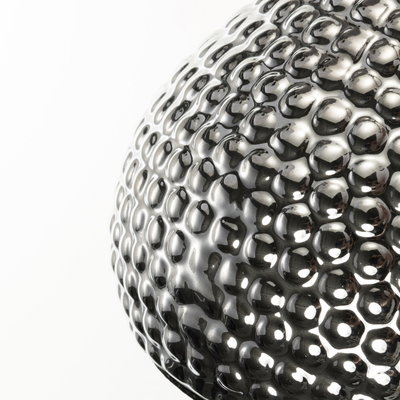 Gros plan d'une lampe sphérique en métal argenté texturé et brillant avec éclairage LED