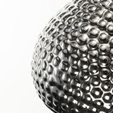 Close-up of a spherical lamp made of shiny, textured silver metal with LED lighting effect