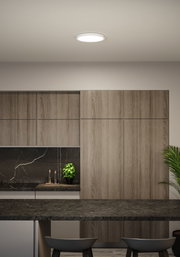Runde weiße LED-Deckenleuchte in moderner Küche mit Holzfronten und schwarzer Arbeitsplatte