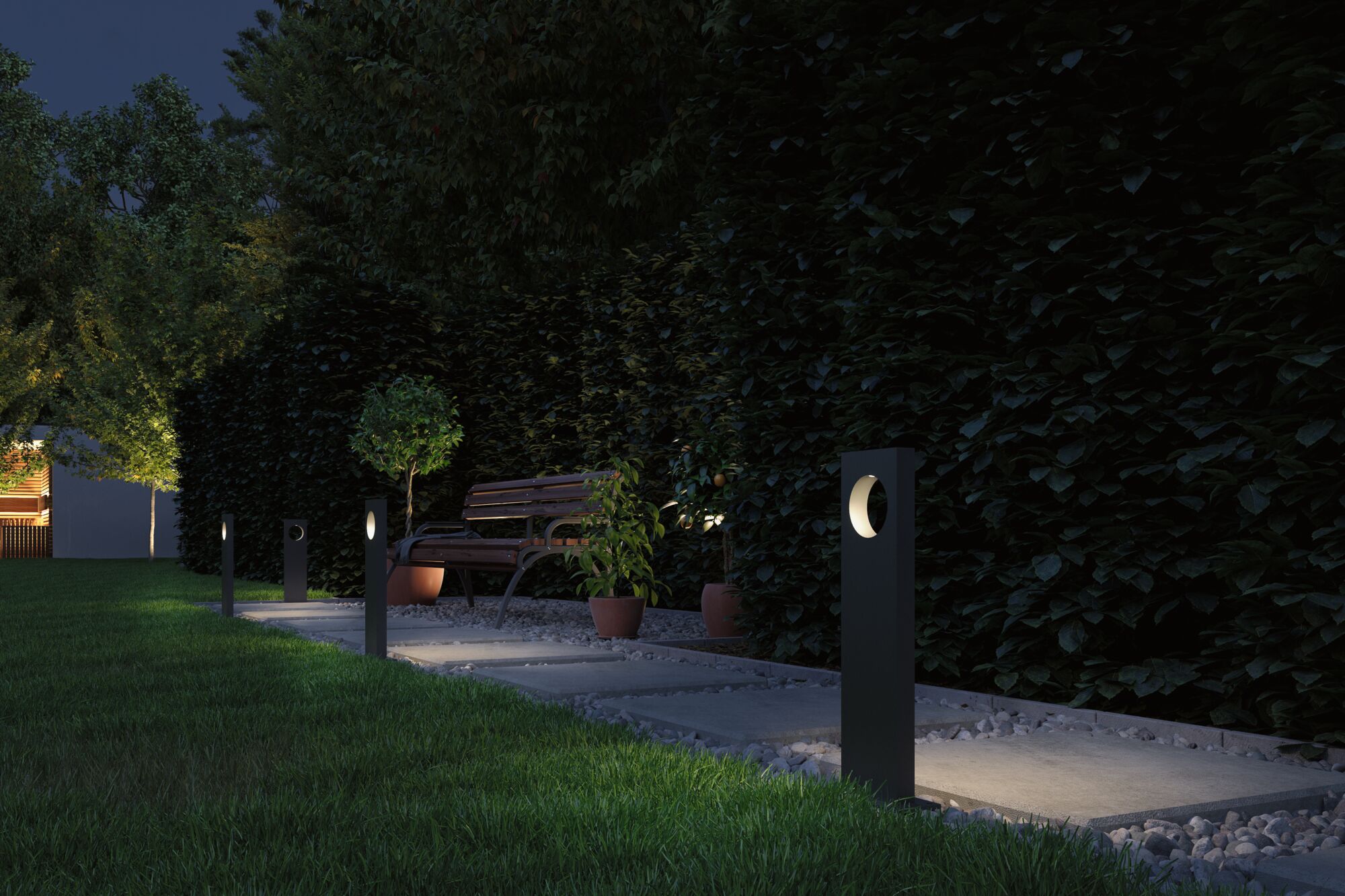 Moderne schwarze Gartenleuchten aus Metall beleuchten Weg mit Bank und Pflanzen bei Nacht