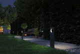 Moderne schwarze Gartenleuchten aus Metall beleuchten Weg mit Bank und Pflanzen bei Nacht