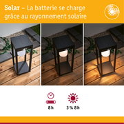 Lampe de jardin solaire noire en métal avec diffuseur blanc sur terrasse en bois de jour comme de nuit