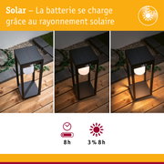 Lampe de jardin solaire noire en métal avec diffuseur blanc sur terrasse en bois de jour comme de nuit