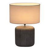 Table lamp with black striped ceramic base and light fabric shade for ambient room lighting