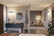 Modernes Wohnzimmer mit beigem Sofa, schwarzem Sideboard und weißen Wandlampen aus Metall für Wohnraumbeleuchtung