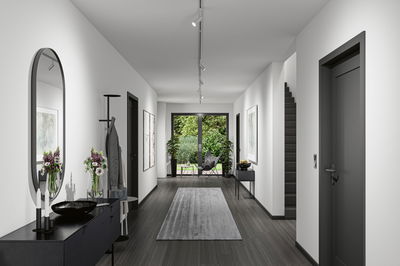 Modern hallway with white walls, grey rug, and black furniture lighting for living space design.