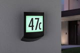 Black LED house number sign with illuminated white-green panel showing number 47c on grey wall