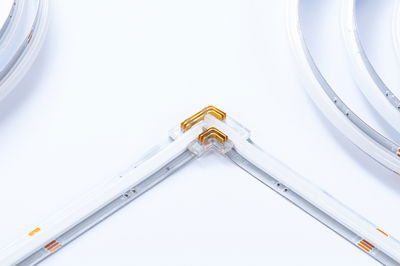 Bande LED avec connecteur d'angle transparent et bandes flexibles blanches pour éclairage moderne.