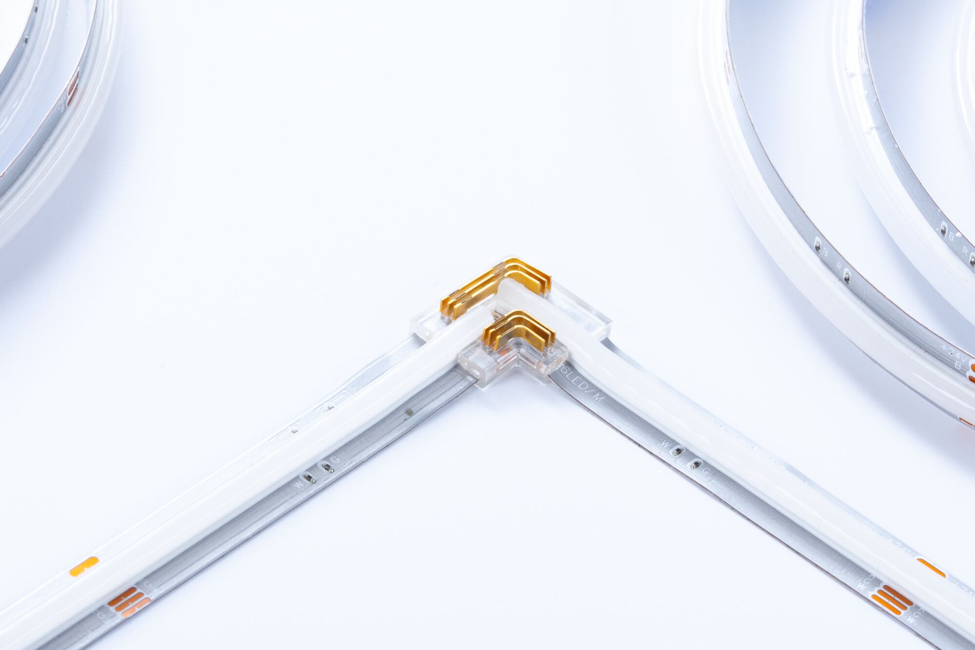 LED light strip with transparent corner connector and white flexible strips for modern lighting.
