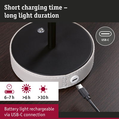 USB-C charging cable connected to round white leather base on dark wood, rechargeable battery light with long duration