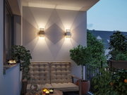 Moderner Außenwandleuchter aus Metall in Grau mit warmweißem Licht auf Balkon mit Sitzbank und Pflanzen