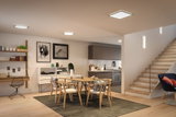 Modernes Esszimmer mit Holzstühlen, Teppich und minimalistischer LED-Deckenbeleuchtung in warmweiß.