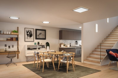 Modernes Esszimmer mit Holzstühlen, Teppich und minimalistischer LED-Deckenbeleuchtung in warmweiß.