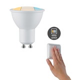 Hvid GU10 LED-pære med farvetemperaturskift og hånd på hvid lyskontakt til styring