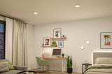 Modern bedroom with white LED ceiling lights and wall lamps, wooden desk and green decor plants