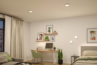 Modern bedroom with white LED ceiling lights and wall lamps, wooden desk and green decor plants