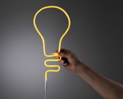 Main tenant une lumière néon jaune flexible en forme d'ampoule en matériau souple pour éclairage décoratif