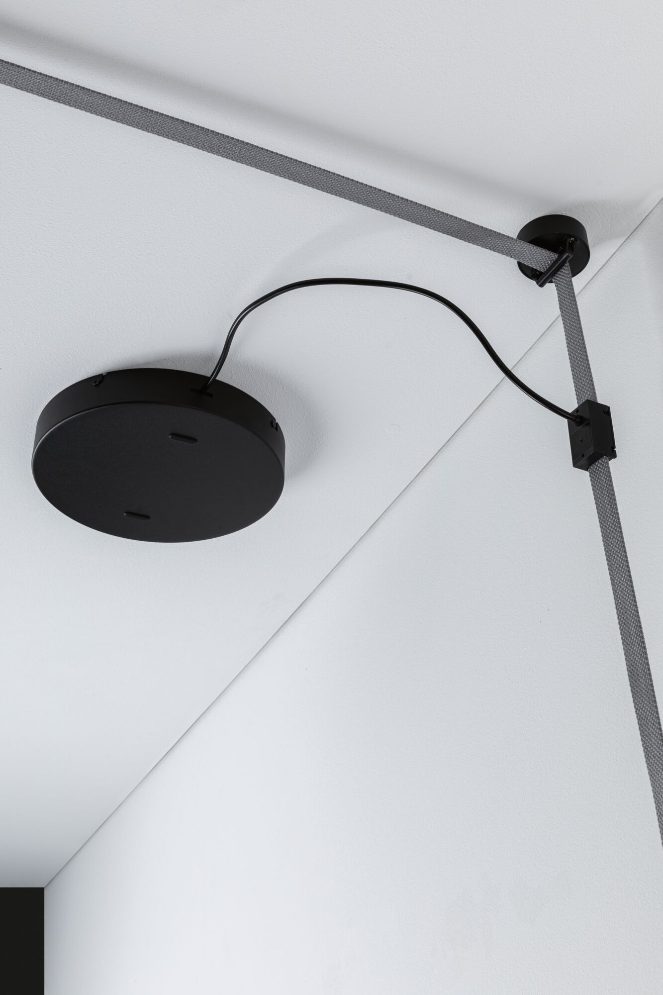 Black round ceiling mount with grey textile cable and clip on white ceiling for modern lighting setup