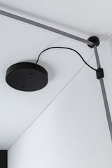 Black round ceiling mount with grey textile cable and clip on white ceiling for modern lighting setup