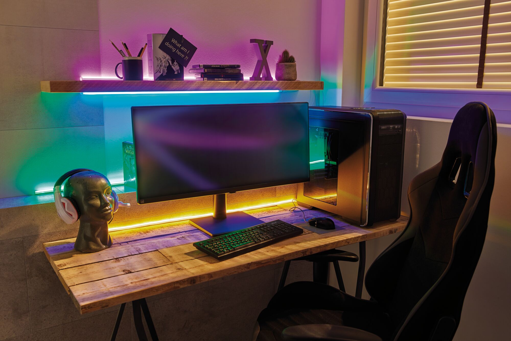 Modern PC desk setup with wooden table, RGB LED lighting, and ergonomic black gaming chair