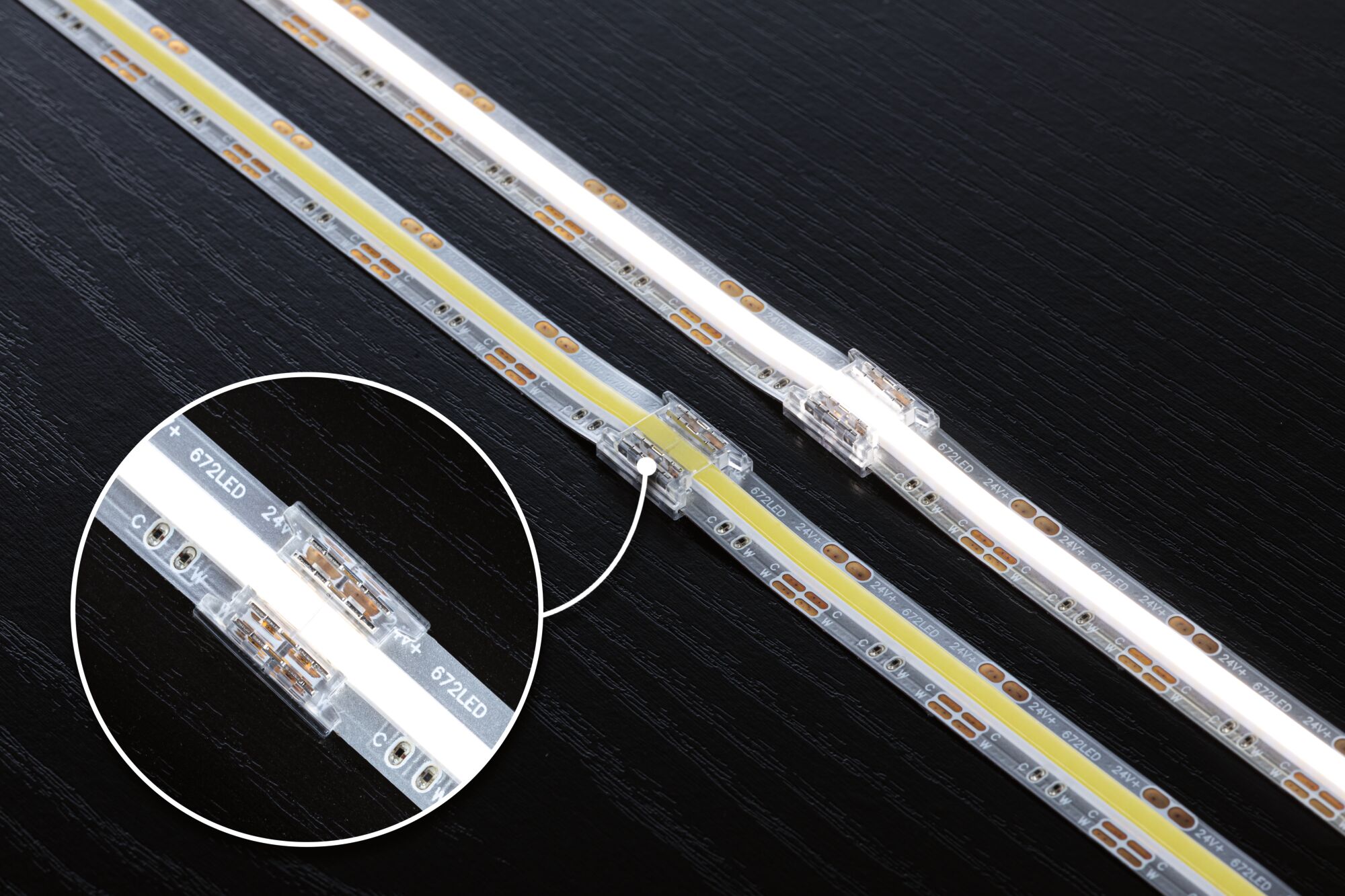 LED-strip med gennemsigtig forbindelse på sort overflade, fleksibel 24V belysningsstribe.