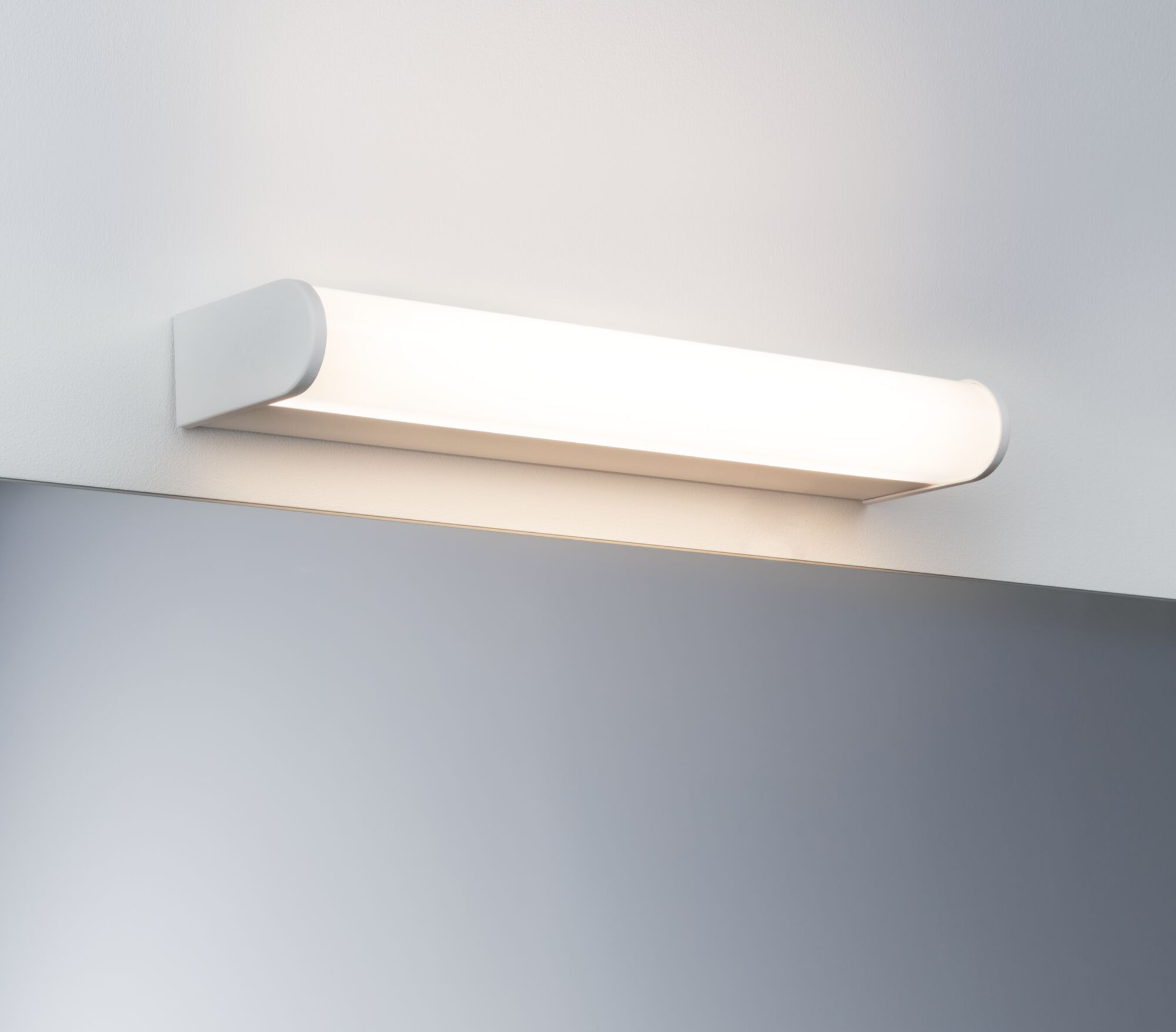 White LED wall light made of plastic above a mirror for modern bathroom lighting