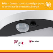 Gros plan d'un détecteur de mouvement blanc avec capteur solaire intégré pour commutation automatique